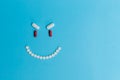 An evil smiling smiley face made of pills on a blue background Royalty Free Stock Photo