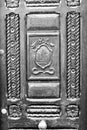 Black and white image of old exterior wooden door inlaid with brass handle Royalty Free Stock Photo