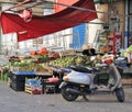 Fruit and vegetable shop with fruit and vegetables displayed for sale and a scooter in the foreground in the historic center of Pa