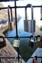 Love pad locks or love padlocks closed on the grate of a bridge with the river in the background positioned by lovers to symbolize Royalty Free Stock Photo