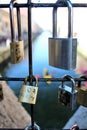 Love pad locks or love padlocks closed on the grate of a bridge with the river in the background positioned by lovers to symbolize Royalty Free Stock Photo