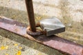 Image of a padlock tied to a rusty pole