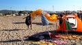 Paraglider landing on a beach with blue sky