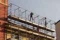 Workers engaged in assembling a scaffolding