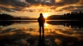 Silhouette of photographer on reflective lake at sunset