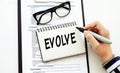 Evolve. text on white notepad on documents Royalty Free Stock Photo