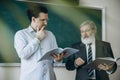 Elderly gray-headed man, professor, teacher and student at lecture, lesson at classroom, indoors. Concept of