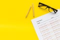 On the exam. Exam sheet, answer near glasses and pencil on yellow background top view space for text Royalty Free Stock Photo