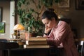 Exam preparation. Student girl in glasses and a pink sweater leaned over books, engaged in an old library at the table. Royalty Free Stock Photo