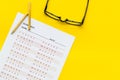 On the exam. Exam sheet, answer near glasses and pencil on yellow background top view space for text Royalty Free Stock Photo