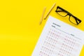 On the exam. Exam sheet, answer near glasses and pencil on yellow background top view space for text Royalty Free Stock Photo