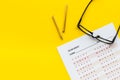 On the exam. Exam sheet, answer near glasses and pencil on yellow background top view space for text Royalty Free Stock Photo