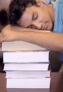 Exam time has gotten to him. A young student sleeping on his desk after a tiring study session.