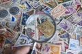 Examination with a magnifying glass of old postage stamps Royalty Free Stock Photo