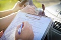 Examiner filling in driver`s license road test form