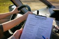 Examiner filling in driver`s license road test form Royalty Free Stock Photo