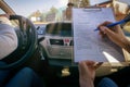 Examiner filling in driver`s license road test form Royalty Free Stock Photo