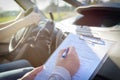 Examiner filling in driver`s license road test form