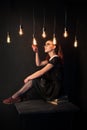 Examines the glow of edison lamps. Girl in retro style with glasses Royalty Free Stock Photo