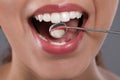 Examining woman`s teeth with dentist`s mirror on grey background, closeup Royalty Free Stock Photo