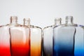 An example of color diffusion. Transparent multi-colored bottles for perfume or liquids on a light background. Without cover. Royalty Free Stock Photo