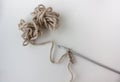 an example of knitting on white background. a small ball of soft beige yarn and a gray crochet hook. Royalty Free Stock Photo