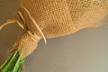 Example of packing a bouquet of flowers in a brown floral grid, close-up on a gray background