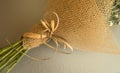 Example of packing a bouquet of flowers in a brown floral grid, close-up on a gray background