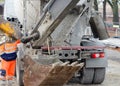 Exavator bucket filled with wet concrete to bring it to place of concrete works on building site Royalty Free Stock Photo