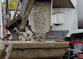 Excavator bucket filled with wet concrete to bring it to place of concrete works Royalty Free Stock Photo