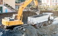 Exavator loading earth in the truck on construction site Royalty Free Stock Photo