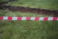 Excavated ground under the foundation of the house, fenced with a red warning tape