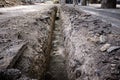 Excavated trench on the road in the city for the reconstruction of the water supply Royalty Free Stock Photo