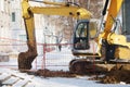 Excavating equipment in a groove on the sidewalk, surrounded by a construction safety net, is prepared for emergency Royalty Free Stock Photo