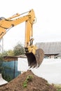 Excavation industrial work. A bulldozer pours out a bucket of land on a construction site close-up Royalty Free Stock Photo