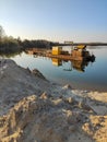 Excavation machine at earthmoving work in sand quarry. Extraction of sand from a lake.