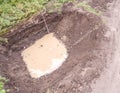 Excavation pit with groundwater ingress and measuring bar, aerial view