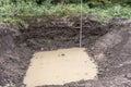 Excavation pit with groundwater ingress and measuring bar