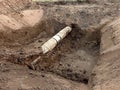 Excavation pit. Old drink water pipe with stainless repairing sleeve members. Royalty Free Stock Photo