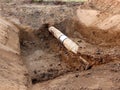 Excavation pit. Old drink water pipe with stainless repairing sleeve members. Royalty Free Stock Photo