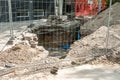 Excavation site for new drinking water pipe valve surrounded with protective metal fence or barrier on the sidewalk with pavement Royalty Free Stock Photo