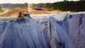 Excavation works for extraction of crushed stone. Stock footage. Top view of tractor loader clearing mountain of rubble