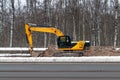 Excavator against the backdrop of a winter forest Royalty Free Stock Photo