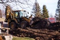 The excavator backfills the pit with the front bucket. Moves soil around the construction site. Heavy construction