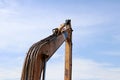 Excavator or backhoe bucket arm in yellow color on blue sky background. Royalty Free Stock Photo