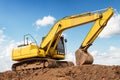 Excavator backhoe on the ground at construction site in blue sky background