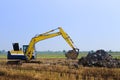 Excavator backhoe working in the digging a soil to adjust the postharvest areas in the rice fields. agriculture machinery for