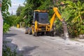 Excavator breaking and drilling the concrete road for repairing. Large pneumatic hammer mounted on the hydraulic arm of a construc