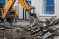 Excavator bucket breaks paving slabs. Sidewalk dismantling and repair work in city