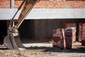 Excavator bucket beside bricks at a renovation site. Royalty Free Stock Photo